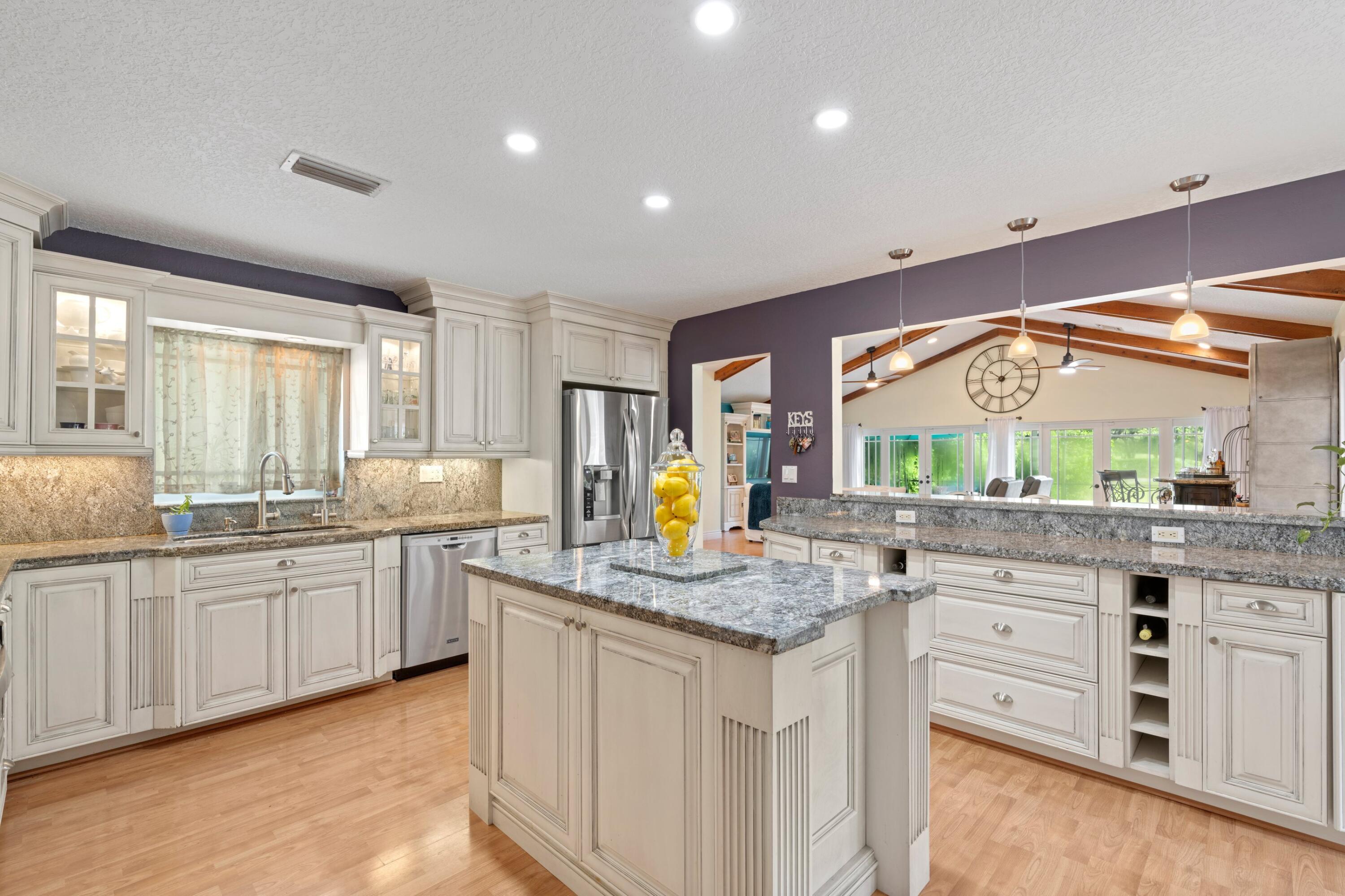 10238 Crosswind Road Boca Raton, FL 33498 - Photo 10 of 42 a kitchen with stainless steel appliances granite countertop stove a sink and a wooden cabinets