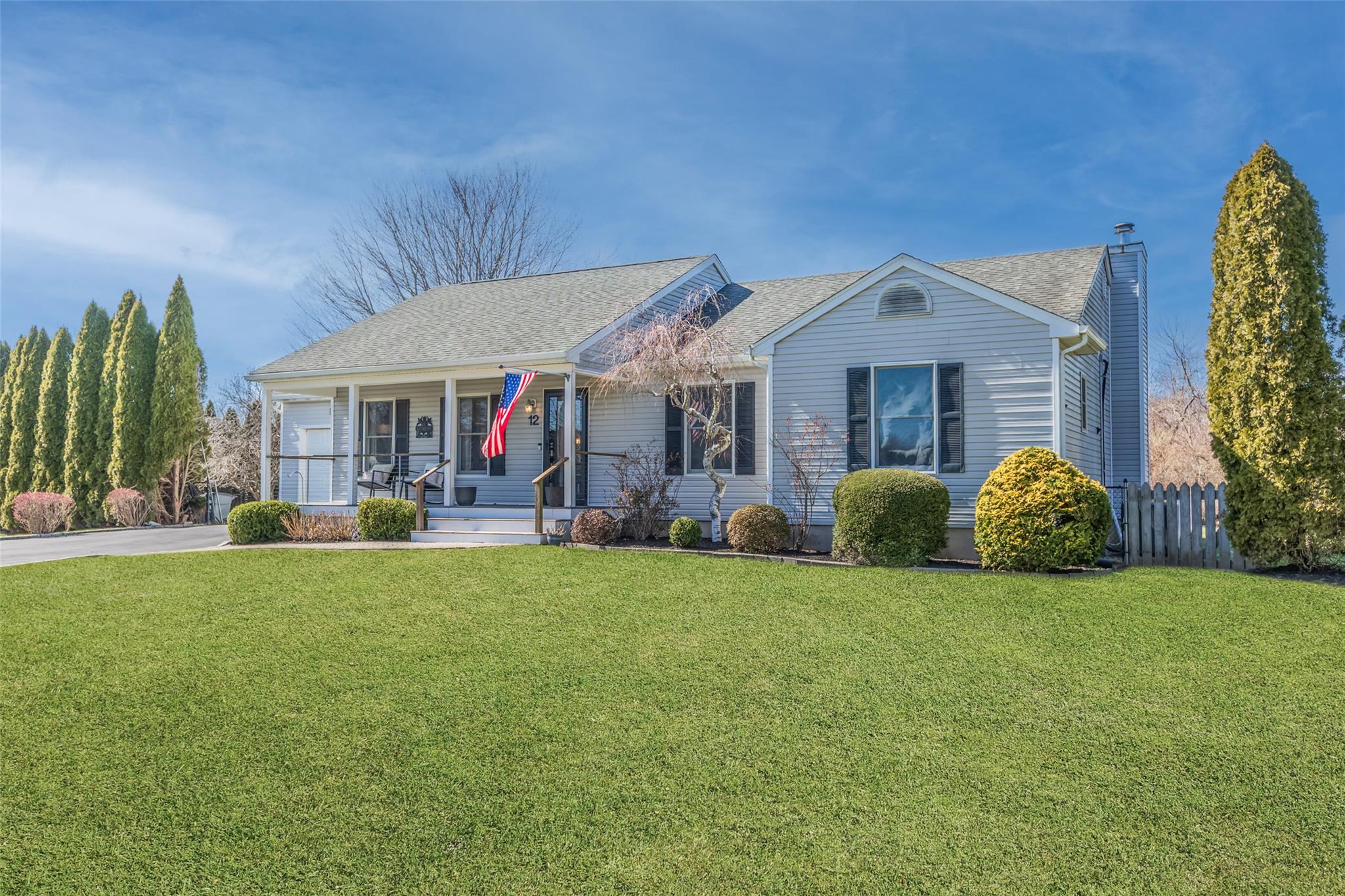 Single story home with a front yard, a porch, fence, and roof with shingles