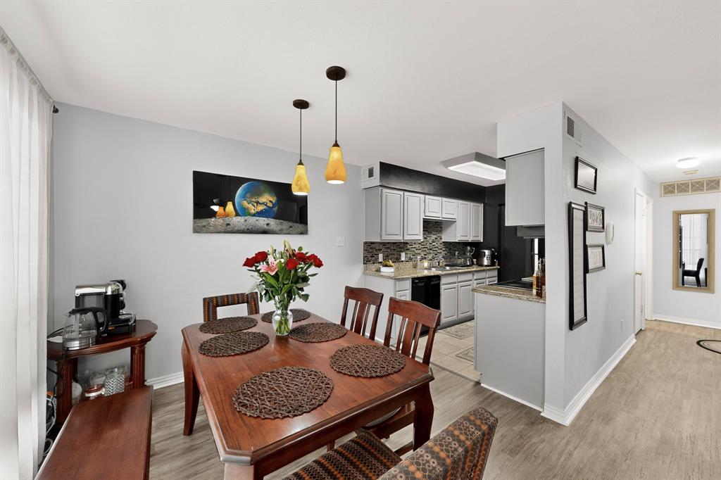 324 West Harwood Road, Unit A Hurst, TX 76054 - Photo 13 of 27 a kitchen with stainless steel appliances granite countertop a stove a refrigerator a kitchen island a dining table and chairs with wooden floor