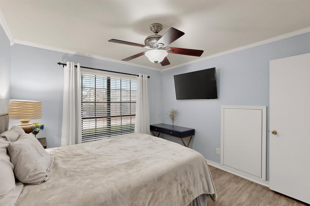 324 West Harwood Road, Unit A Hurst, TX 76054 - Photo 17 of 27 a bedroom with a bed and a flat screen tv