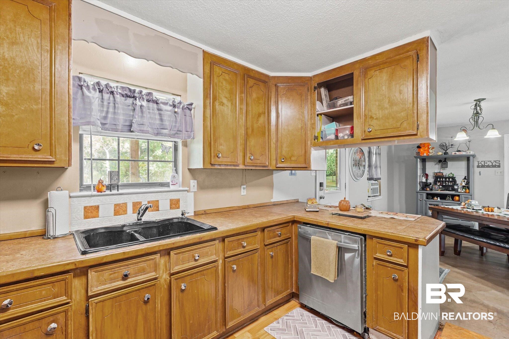 11440 Diffee Road Grand Bay, AL 36541 - Photo 9 of 22 Kitchen with light countertops, dishwasher, a peninsula, wood finish cabinets, and a textured ceiling