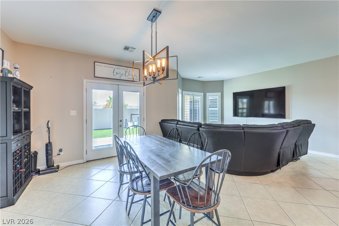 580 Lillian Condie Road Overton, NV 89040 - Photo 12 of 37 An open concept living and dining area boasts tile flooring, a contemporary chandelier, and direct access to the backyard.