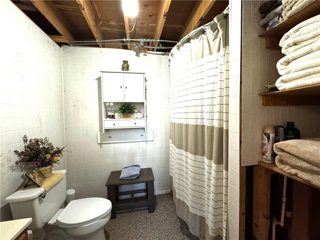 370 Braddock Road Farmington, PA 15437 - Photo 22 of 46 a bathroom with a toilet a sink and a shower curtain