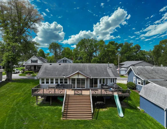 an aerial view of a house with swimming pool next to a yard