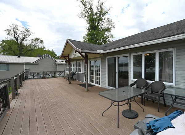 a view of a house with wooden deck and furniture