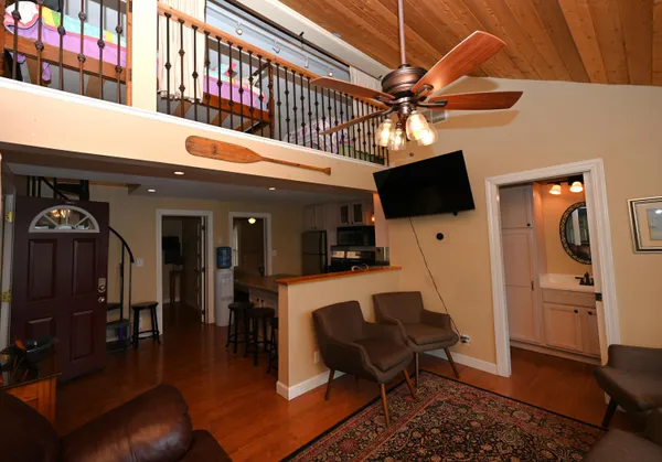 a living room with furniture a flat screen tv and kitchen view