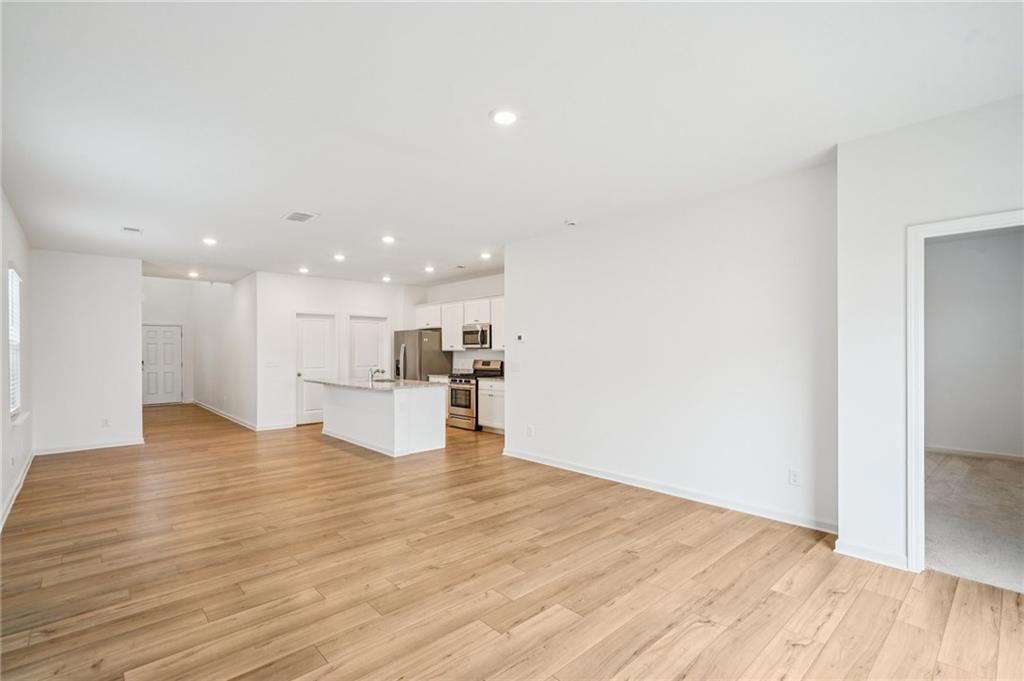 3853 Rustic Barn Way Loganville, GA 30052 - Photo 7 of 22 a view of kitchen with kitchen island wooden floor center island and stainless steel appliances