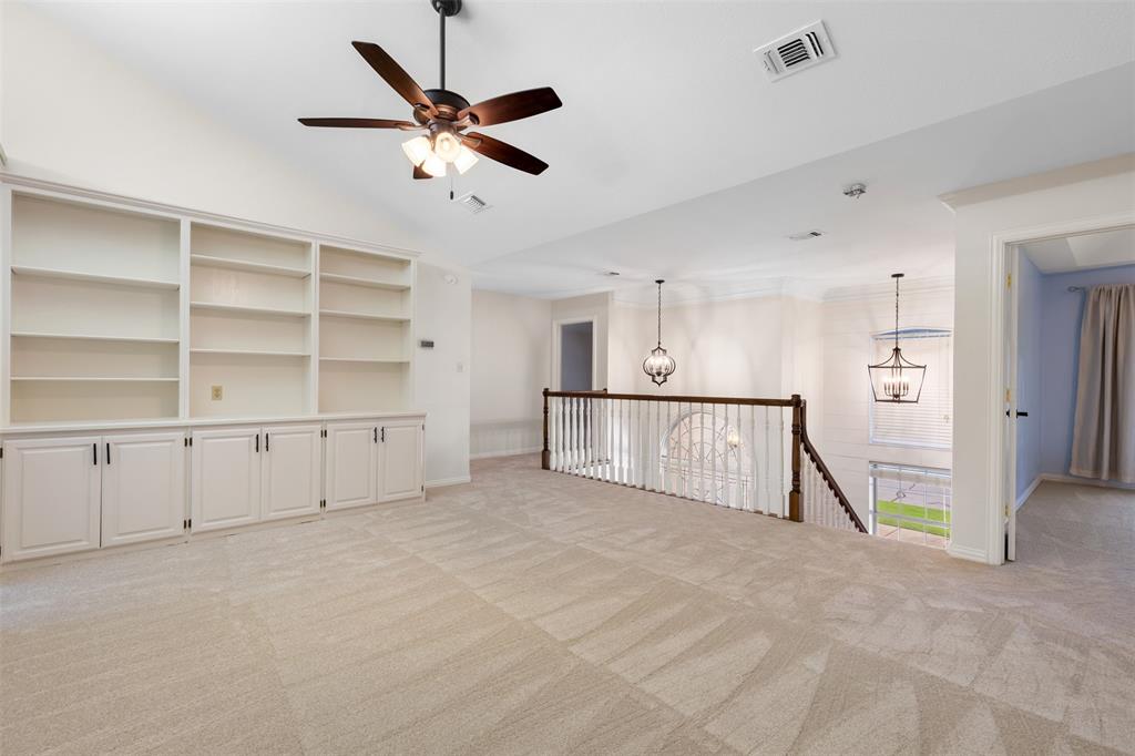 609 Seville Road Denton, TX 76205 - Photo 27 of 40 Upstairs living room with carpet & built-in storage-shelves.