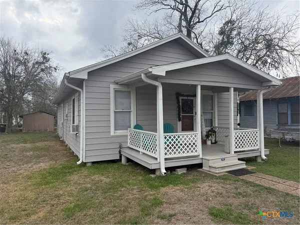 a view of a house with a yard and wooden fence