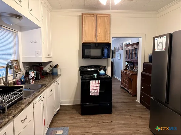 a kitchen with stainless steel appliances granite countertop a refrigerator a stove top oven a sink and dishwasher