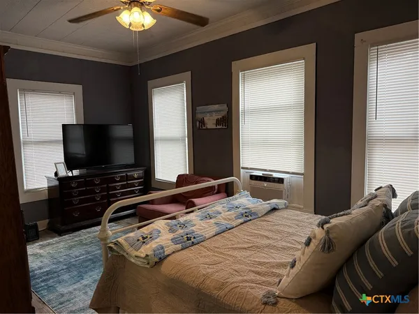 a bedroom with a bed and a flat screen tv