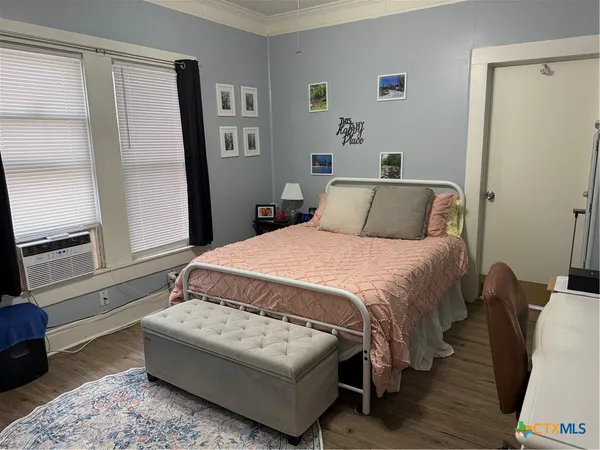 a bedroom with a bed couch and a window