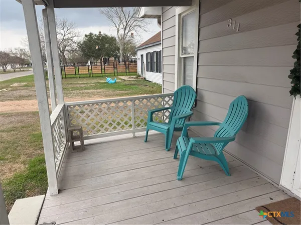 a view of backyard with deck and outdoor seating