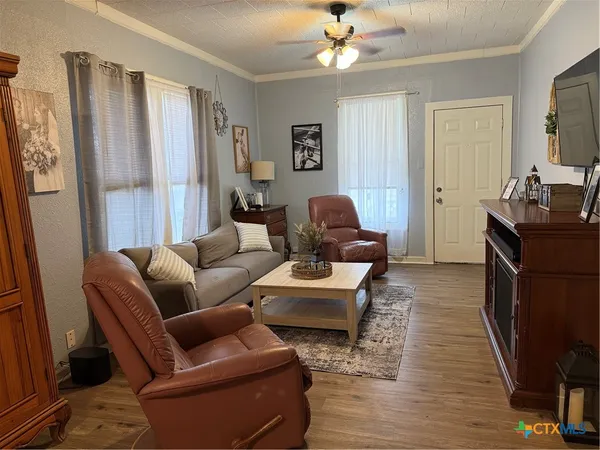 a living room with furniture a ceiling fan and a window