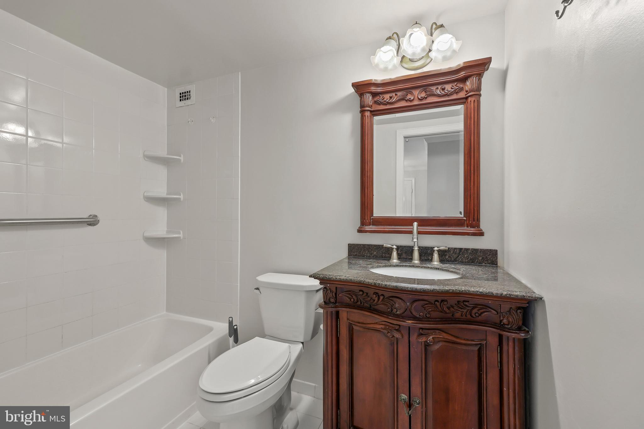 1200 South Arlington Ridge Road, Unit 404 Arlington, VA 22202 - Photo 14 of 32 a bathroom with a granite countertop sink toilet a mirror and shower