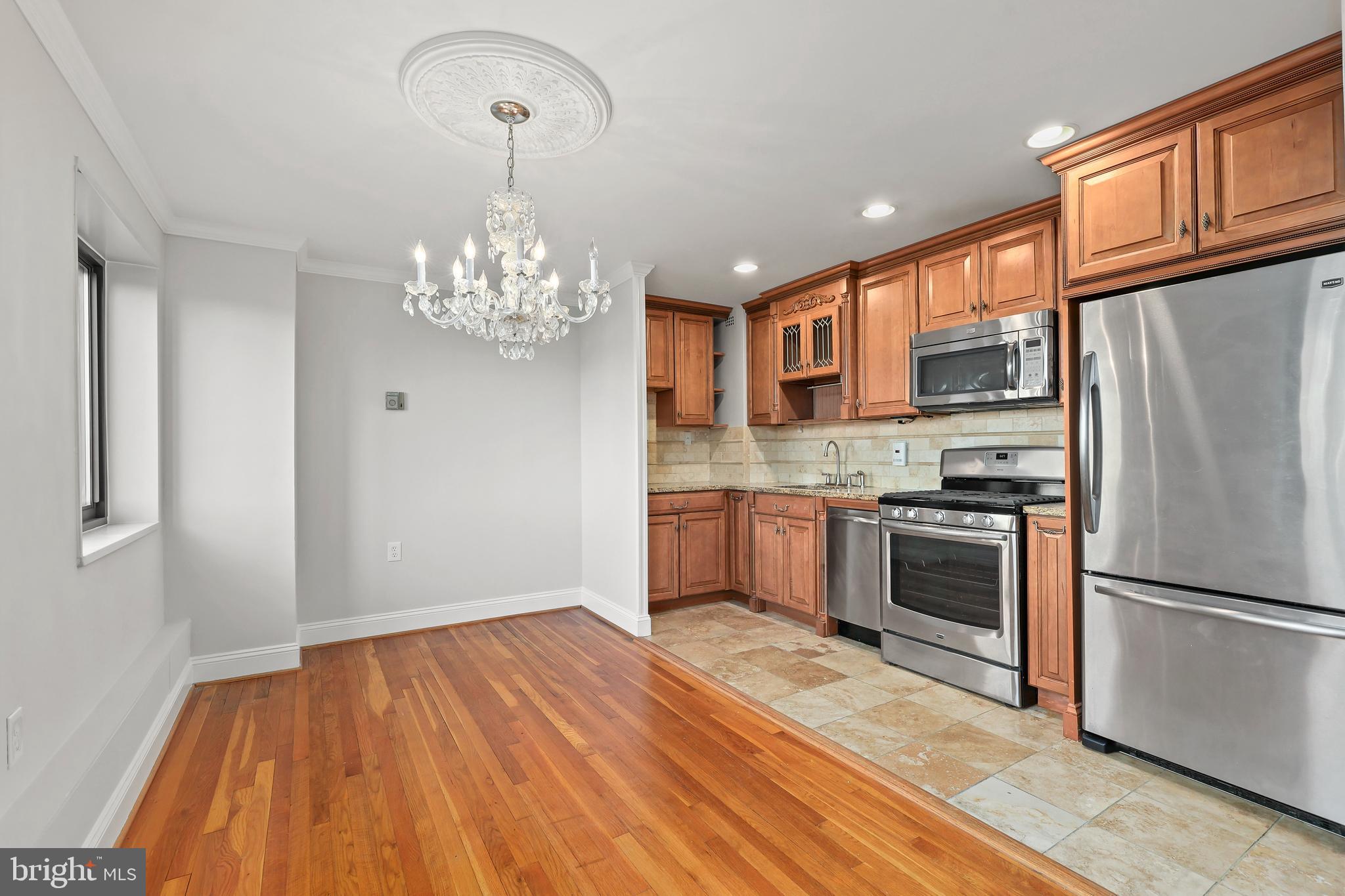 1200 South Arlington Ridge Road, Unit 404 Arlington, VA 22202 - Photo 7 of 32 a kitchen with stainless steel appliances granite countertop a refrigerator oven a sink dishwasher and a stove with wooden floor