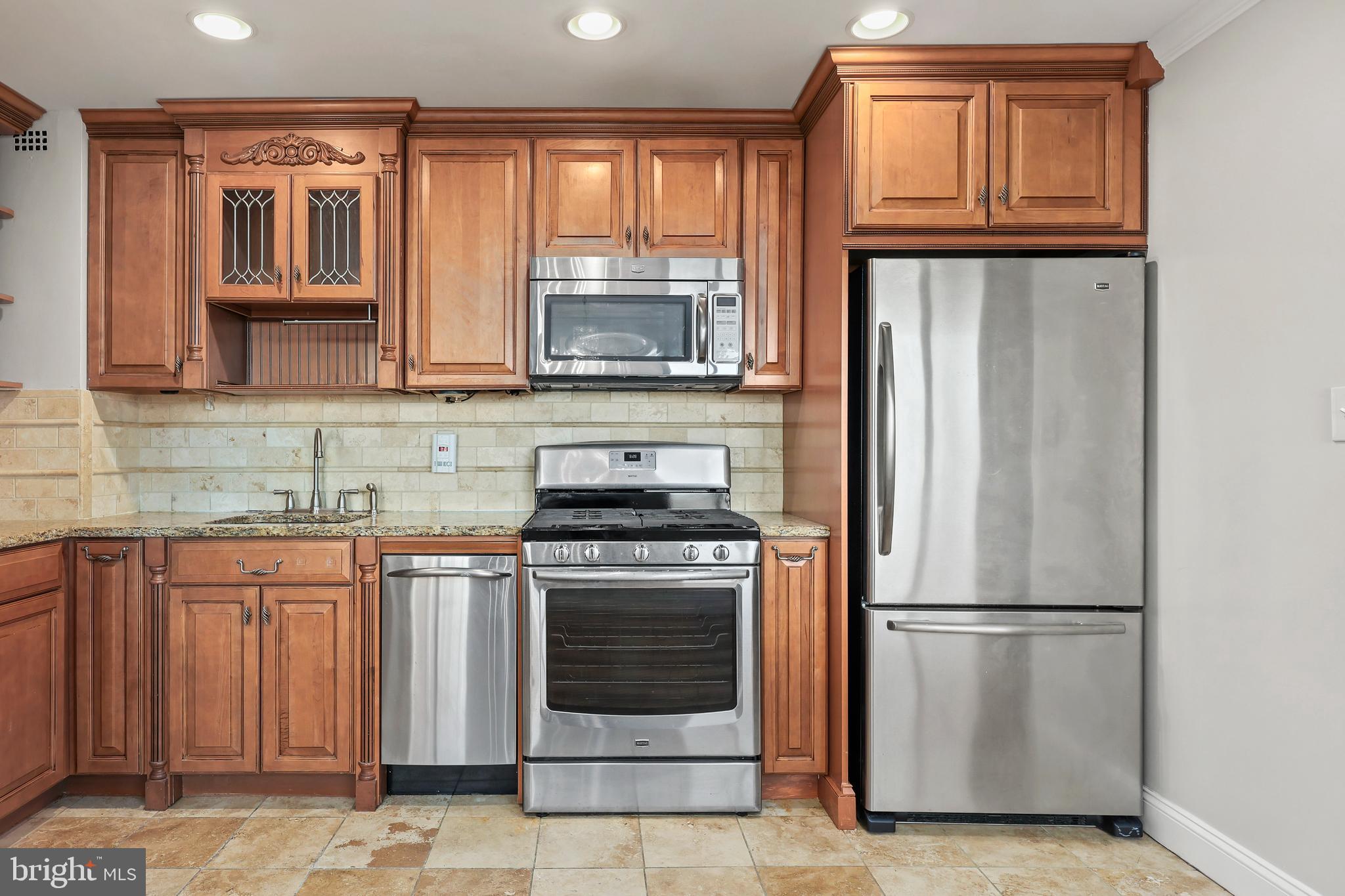 1200 South Arlington Ridge Road, Unit 404 Arlington, VA 22202 - Photo 9 of 32 a kitchen with granite countertop a refrigerator and a stove top oven