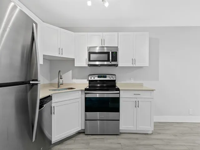 a close view of kitchen with refrigerator cabinets and microwave