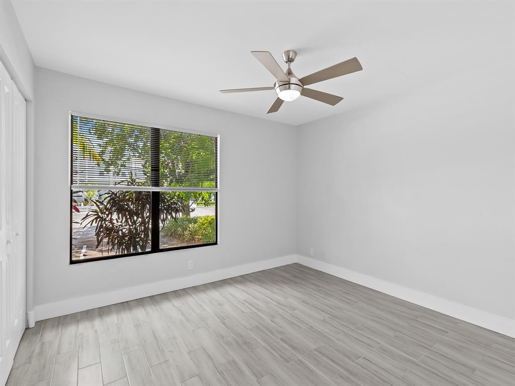 3208 Northeast 7th Street, Unit C Pompano Beach, FL 33062 - Photo 9 of 10 an empty room with wooden floor fan and windows