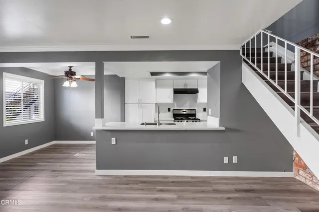 a kitchen with stainless steel appliances granite countertop a refrigerator a stove and a sink