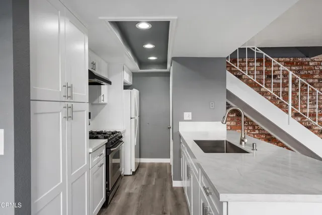 a kitchen with stainless steel appliances granite countertop a refrigerator and a stove top oven
