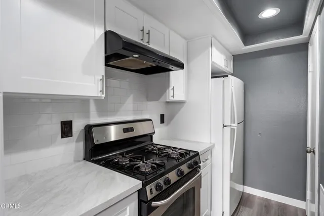 a view of a kitchen with wooden floor and windows