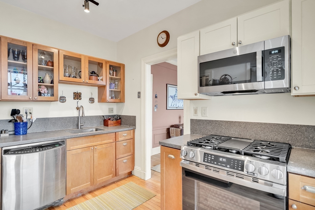 321 Tappan Street, Unit 3 Brookline, MA 02445 - Photo 17 of 39 a kitchen with stainless steel appliances granite countertop a stove a sink dishwasher and a microwave oven with wooden cabinets