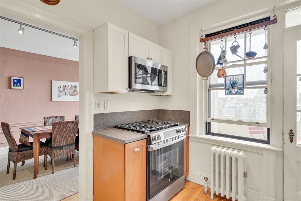 321 Tappan Street, Unit 3 Brookline, MA 02445 - Photo 18 of 39 a kitchen with stainless steel appliances granite countertop a stove a sink and a dining table with cabinet