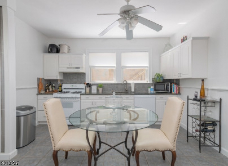 306 Springfield Avenue, Unit 1 Summit, NJ 07901 - Photo 7 of 8 a kitchen with stainless steel appliances granite countertop a table chairs and a refrigerator