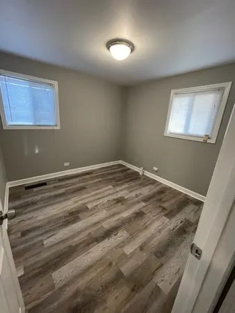 a view of room with wooden floor and windows
