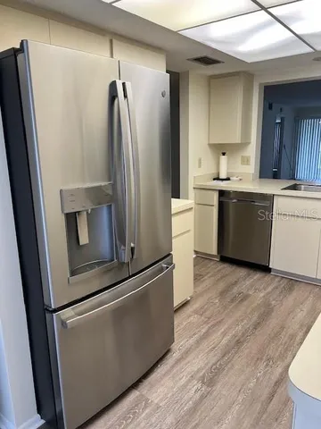 a kitchen with a refrigerator sink and cabinets