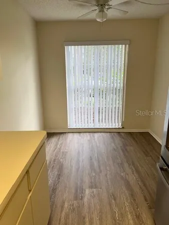 an empty room with wooden floor and a window