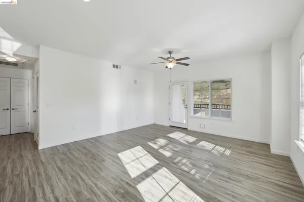 a view of empty room with wooden floor and window