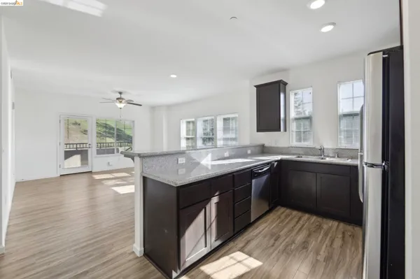 a kitchen with stainless steel appliances granite countertop a refrigerator sink and cabinets