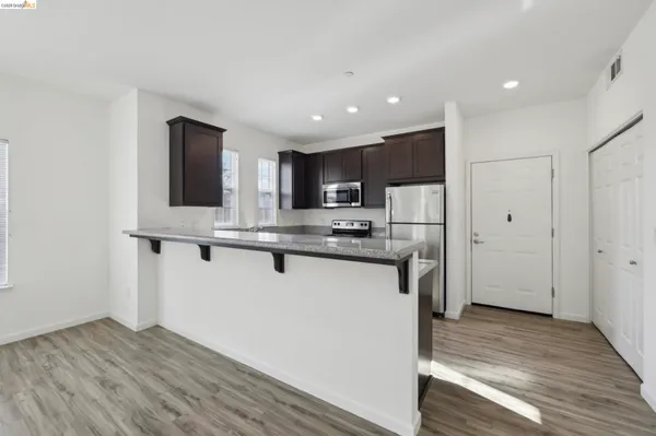 a kitchen with granite countertop a sink stove and refrigerator
