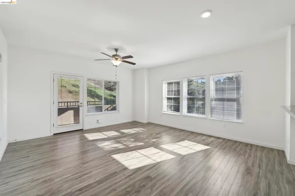 a view of kitchen with stainless steel appliances wooden floor and window