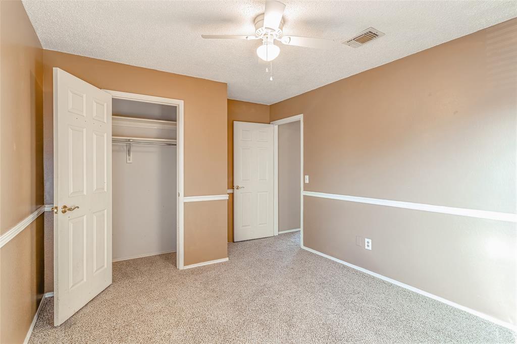 716 Bridget Way Hurst, TX 76054 - Photo 23 of 33 Unfurnished bedroom featuring carpet, a textured ceiling, ceiling fan, and a closet