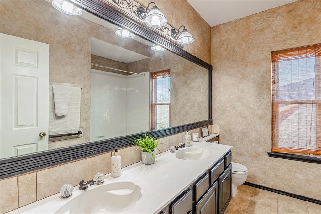 716 Bridget Way Hurst, TX 76054 - Photo 29 of 33 Full bath featuring tiled shower, double vanity, and light tile patterned floors