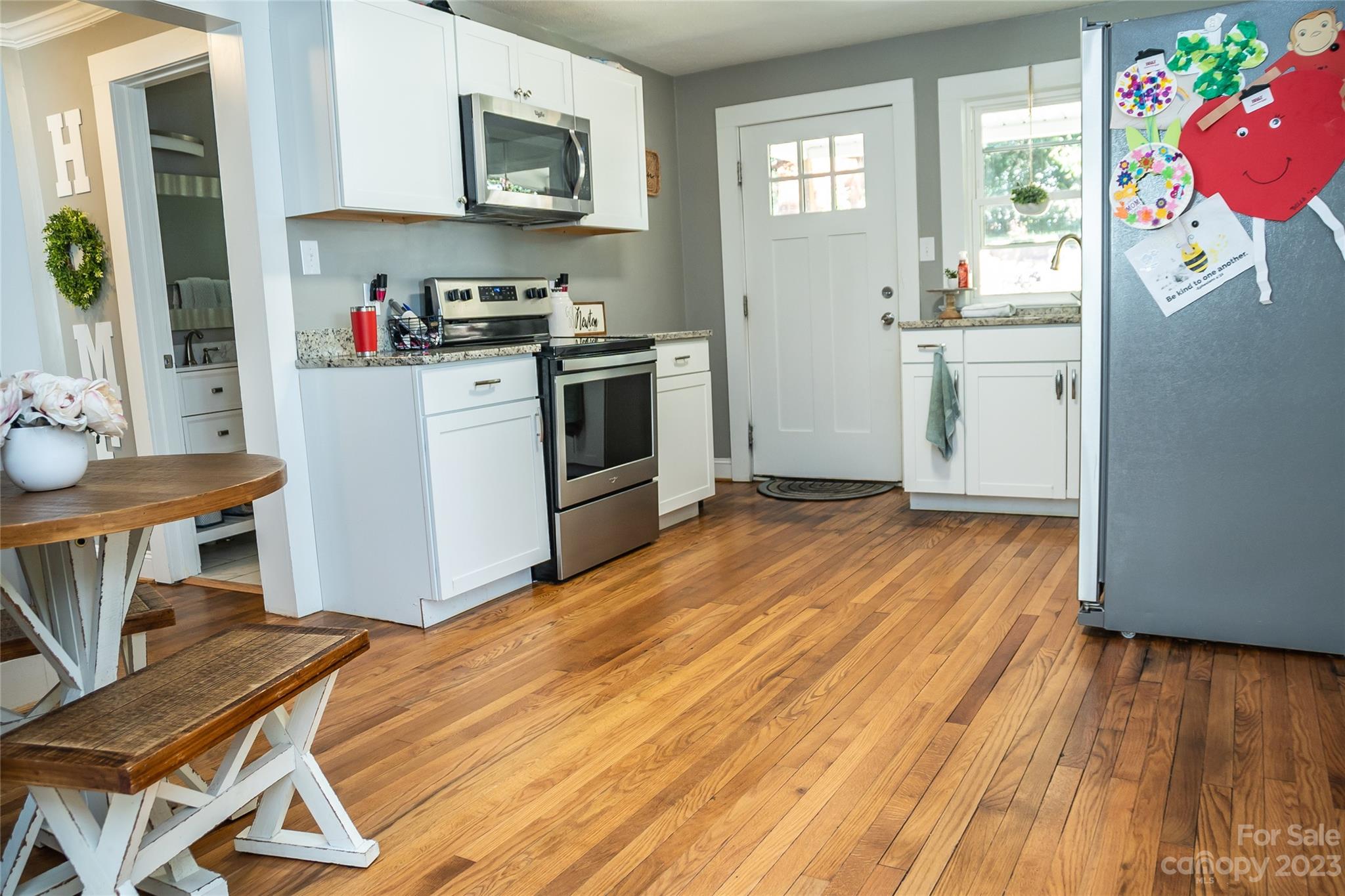 106 Cascade Street Morganton, NC 28655 - Photo 12 of 36 a kitchen with a wooden floor and white appliances
