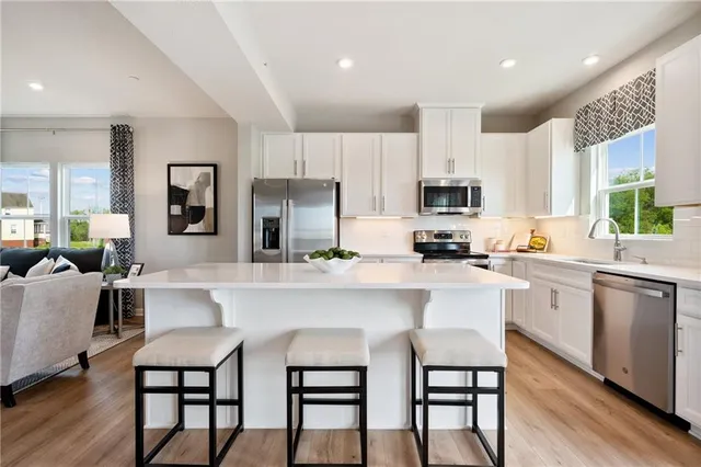 a kitchen with a table chairs microwave and cabinets
