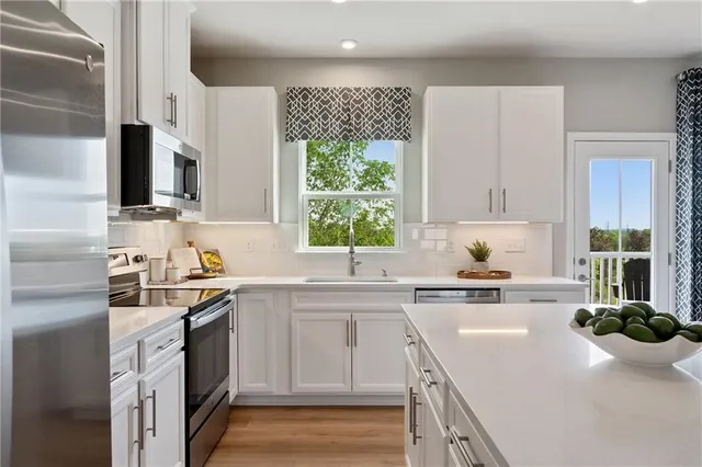 a kitchen with a sink a stove a window and cabinets