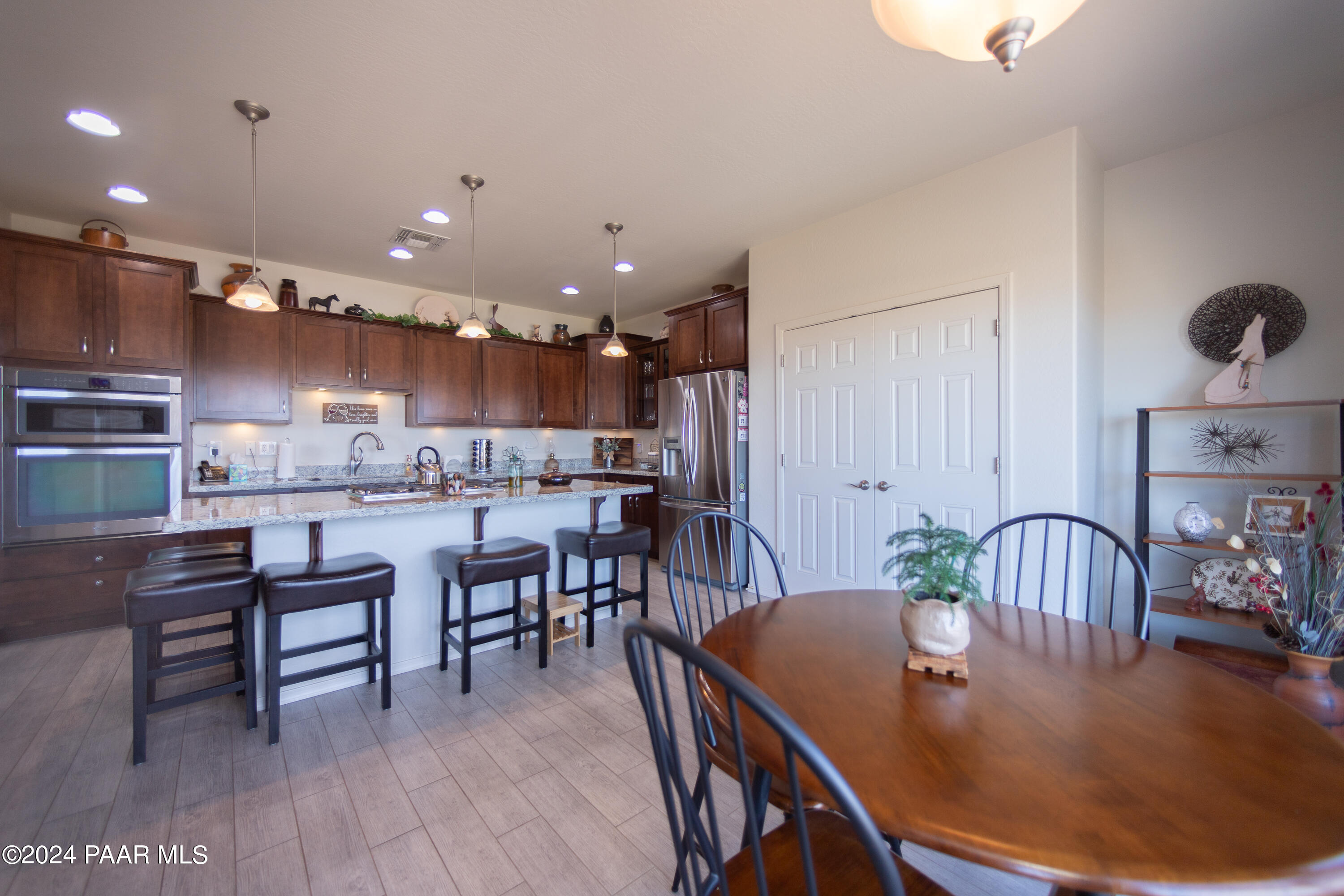 1109 Stack Rock Road Prescott Valley, AZ 86314 - Photo 13 of 91 a dining room with stainless steel appliances kitchen island granite countertop a dining table chairs and view living room
