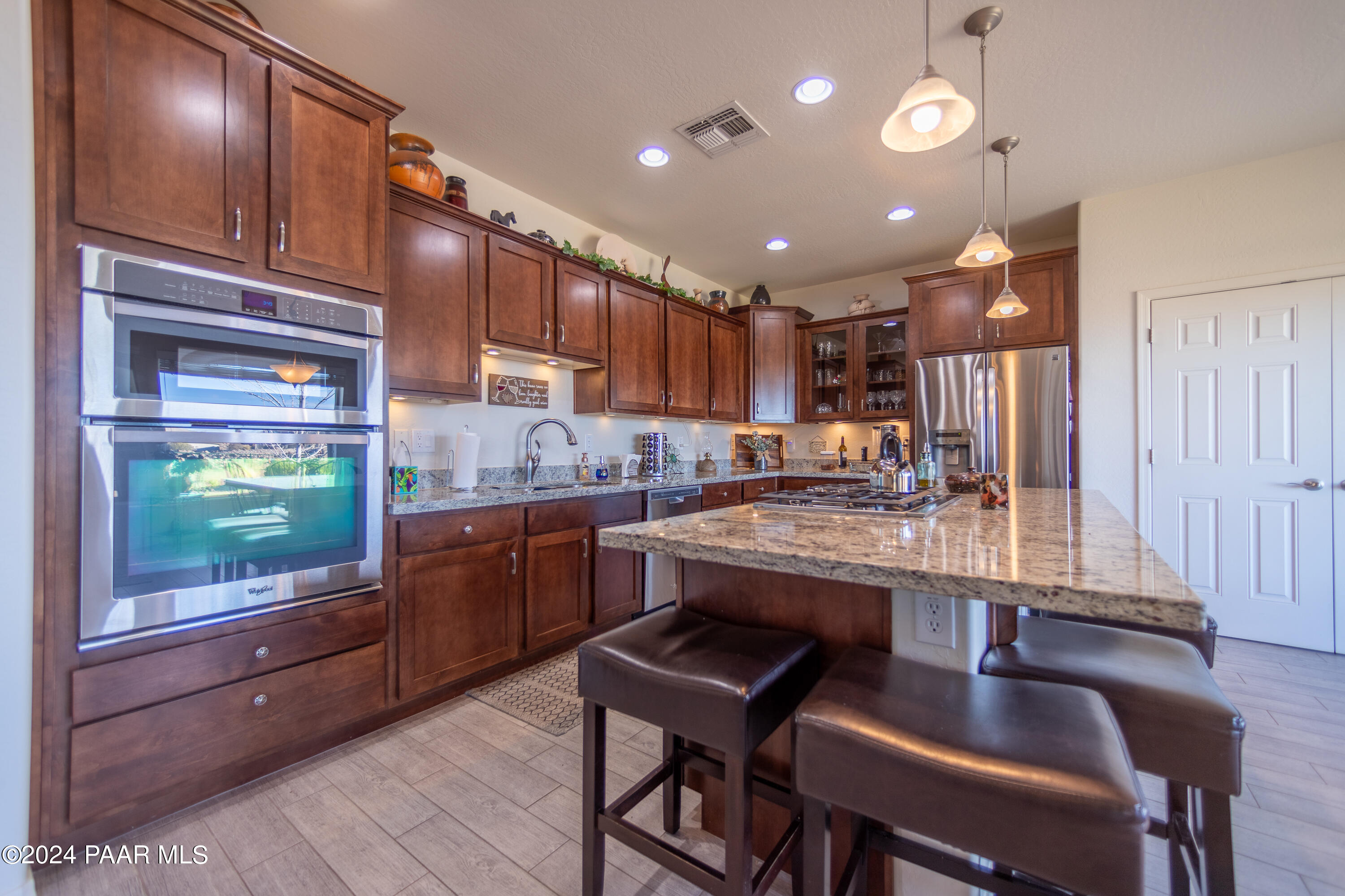 1109 Stack Rock Road Prescott Valley, AZ 86314 - Photo 14 of 91 a kitchen with kitchen island granite countertop wooden cabinets and counter space