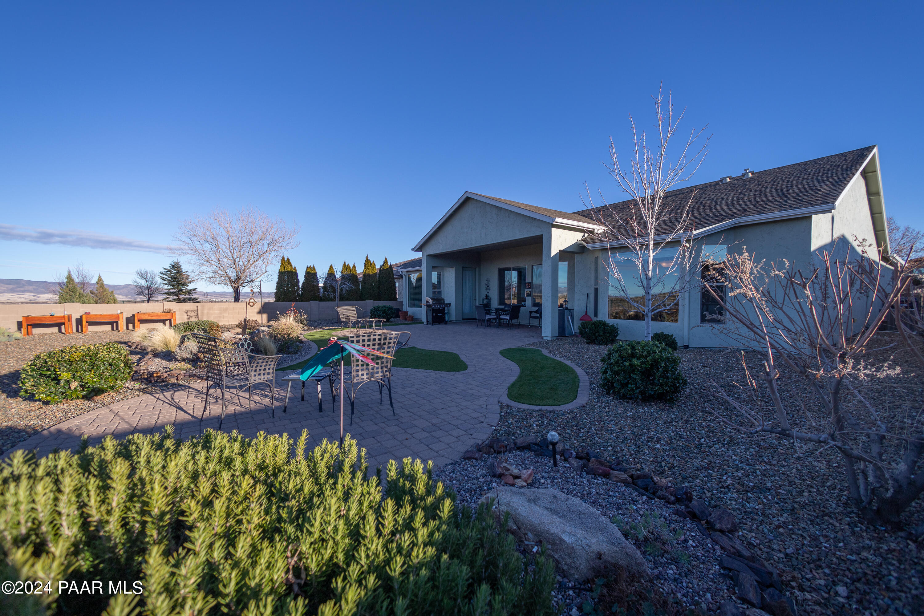 1109 Stack Rock Road Prescott Valley, AZ 86314 - Photo 64 of 91 a view of a patio with couches table and chairs under an umbrella