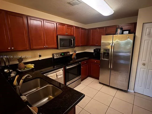 a kitchen with a refrigerator a sink and cabinets
