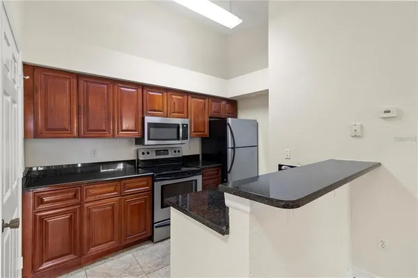 a kitchen with stainless steel appliances granite countertop a stove a sink dishwasher and a refrigerator