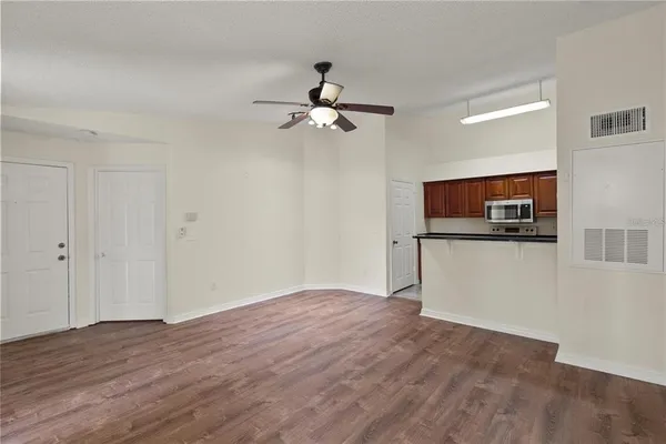 a view of a kitchen with wooden floor and a ceiling fan