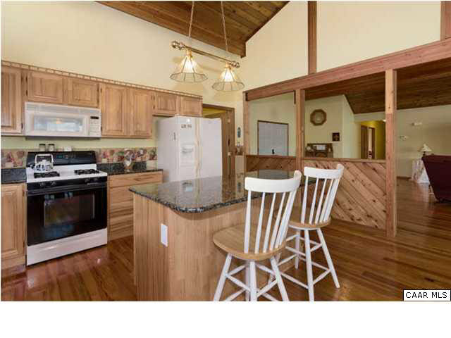452 Buffalo Run Road Stanardsville, VA 22973 - Photo 10 of 26 a kitchen with a table chairs refrigerator and cabinets