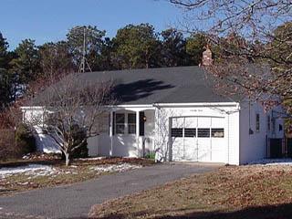 Undisclosed Address Centerville, MA 02632 - Photo 2 of 4 a view of a house with a yard and large tree