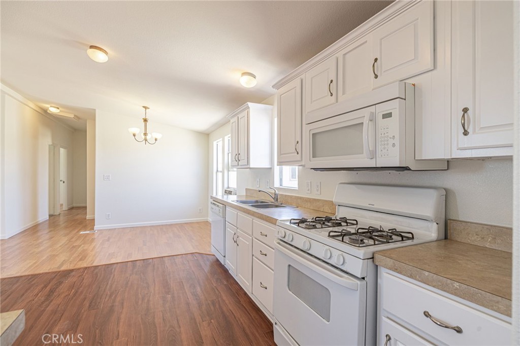 26321 Olanche Street Mojave, CA 93501 - Photo 14 of 39 a kitchen with granite countertop wooden cabinets stove and sink